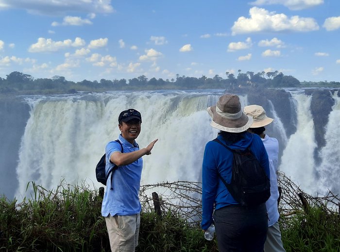 Guests and a guide looking across Victoria Falls