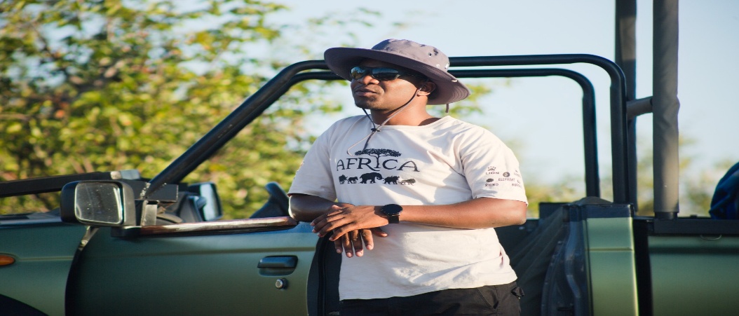 A DK Tours guide beside an open safari vehicle